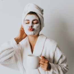 Woman with an at home facial ad coffee