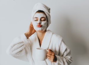 Woman with an at home facial ad coffee