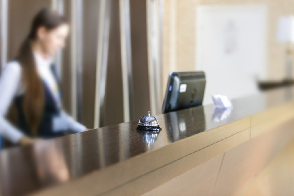 hotel front desk with woman in background
