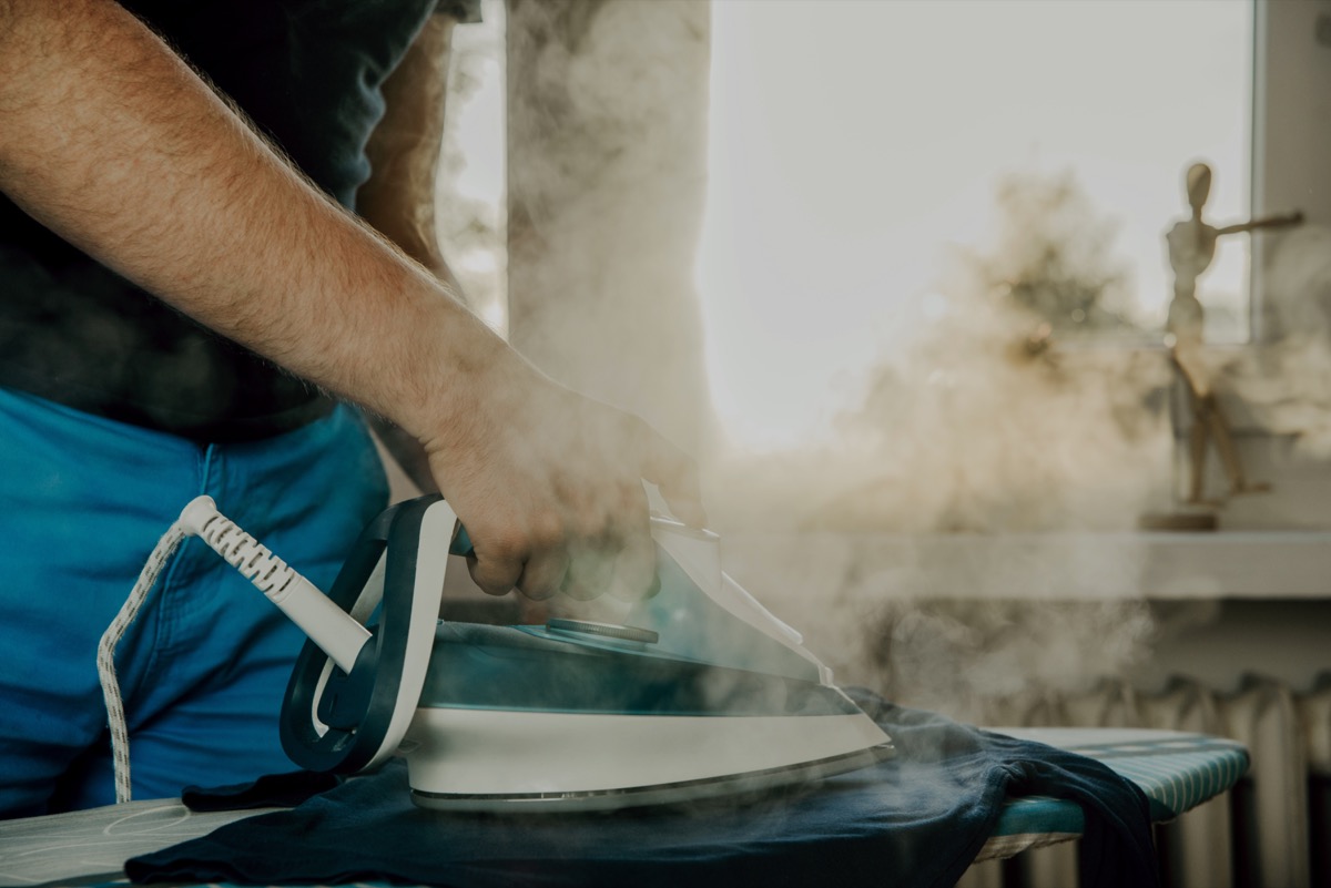 man steaming clothes with an iron
