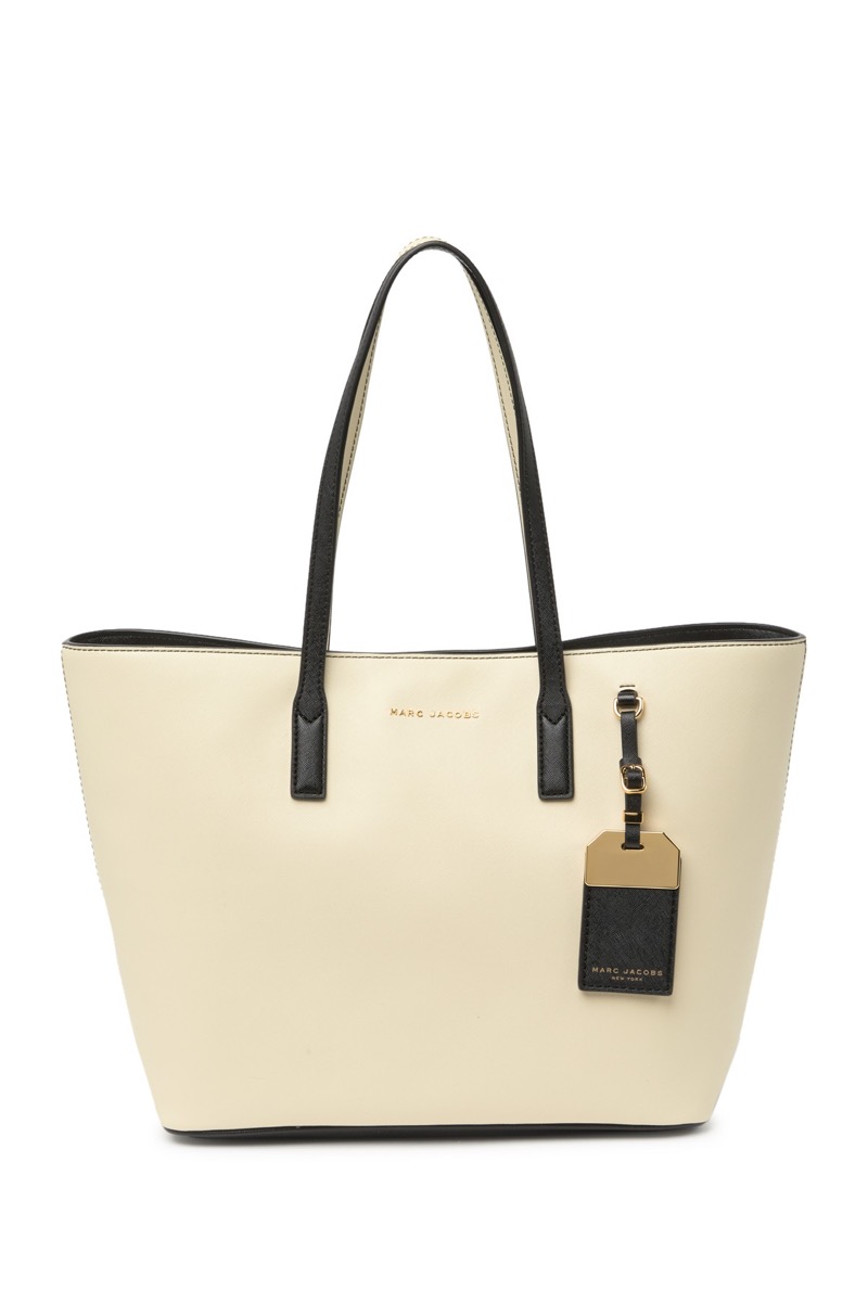 white faux leather tote with black handles and luggage tag