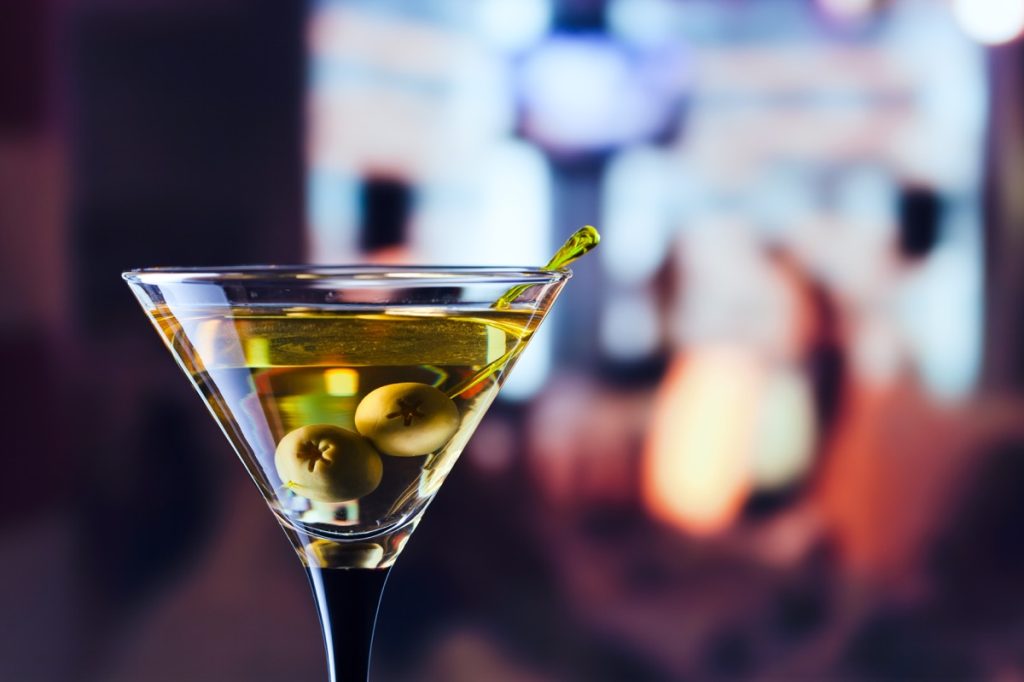 martini in a glass with two olives