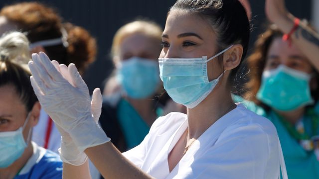 A Coruna-Spain.Healthcare workers dealing with the new coronavirus crisis applaud in return as they are cheered on by Civil Guard and other security forces outside the Hospital on March 26,2020