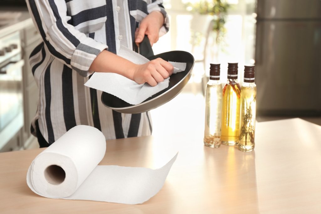 Woman using paper towel to dry pan