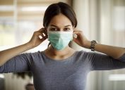 Portrait of young woman putting on a protective mask for coronavirus isolation