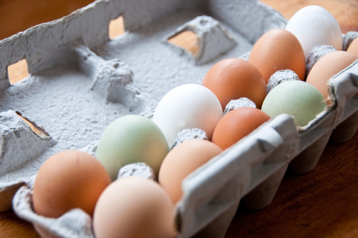 close up of carton of different colored chicken eggs