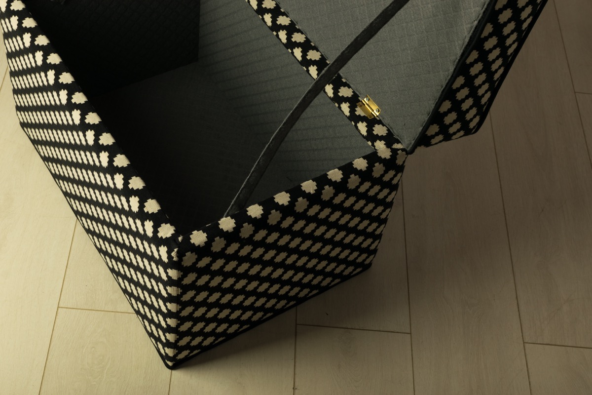 black and white storage ottoman with open lid