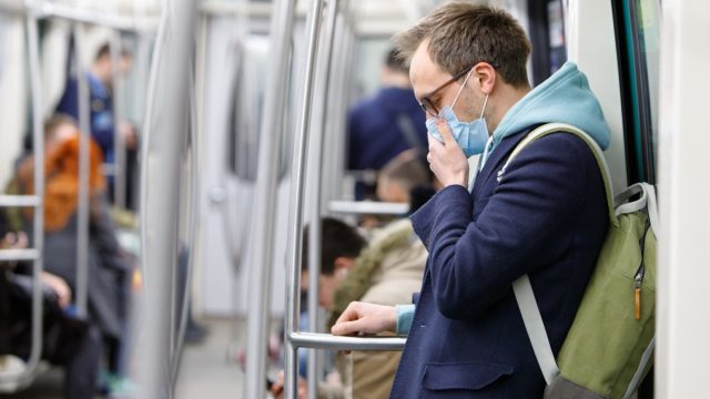 Man wearing a face mask on a subway