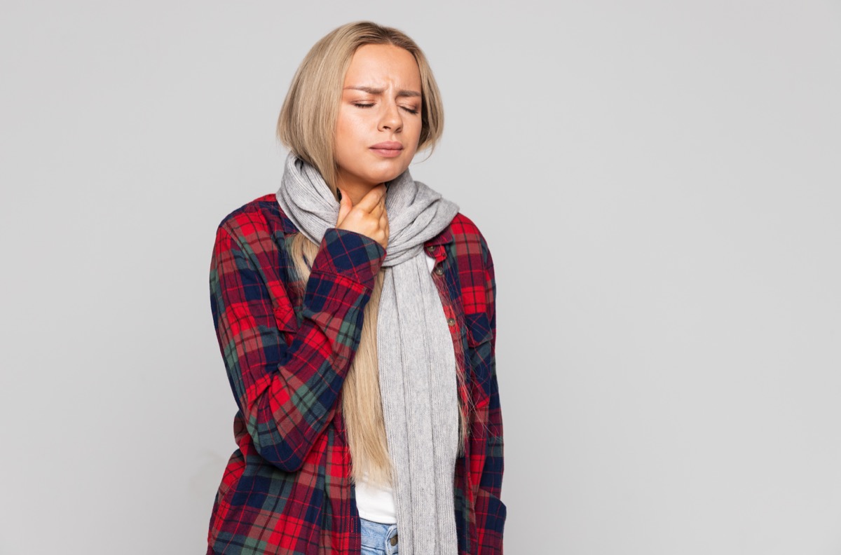 Woman holding throat lymph nodes feeling sick