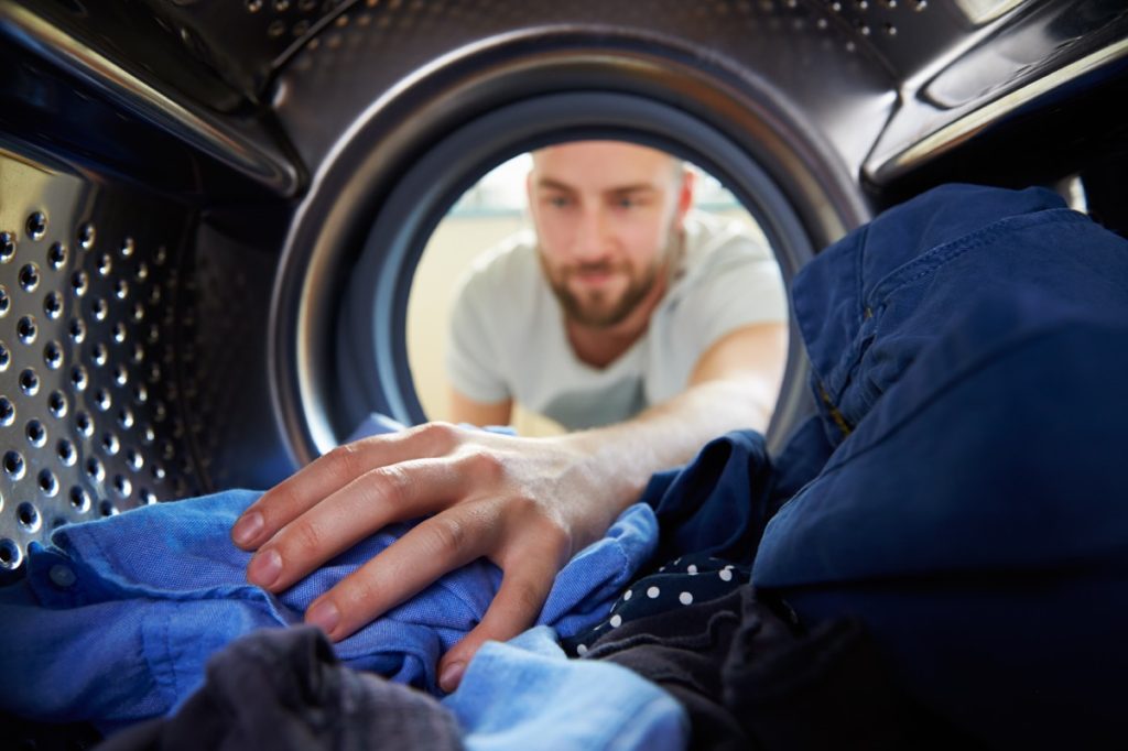 man washing his blue laundry