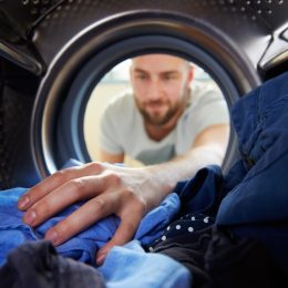 man washing his blue laundry