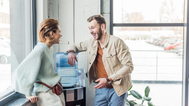 casual businessman and woman talking and laughing in loft office