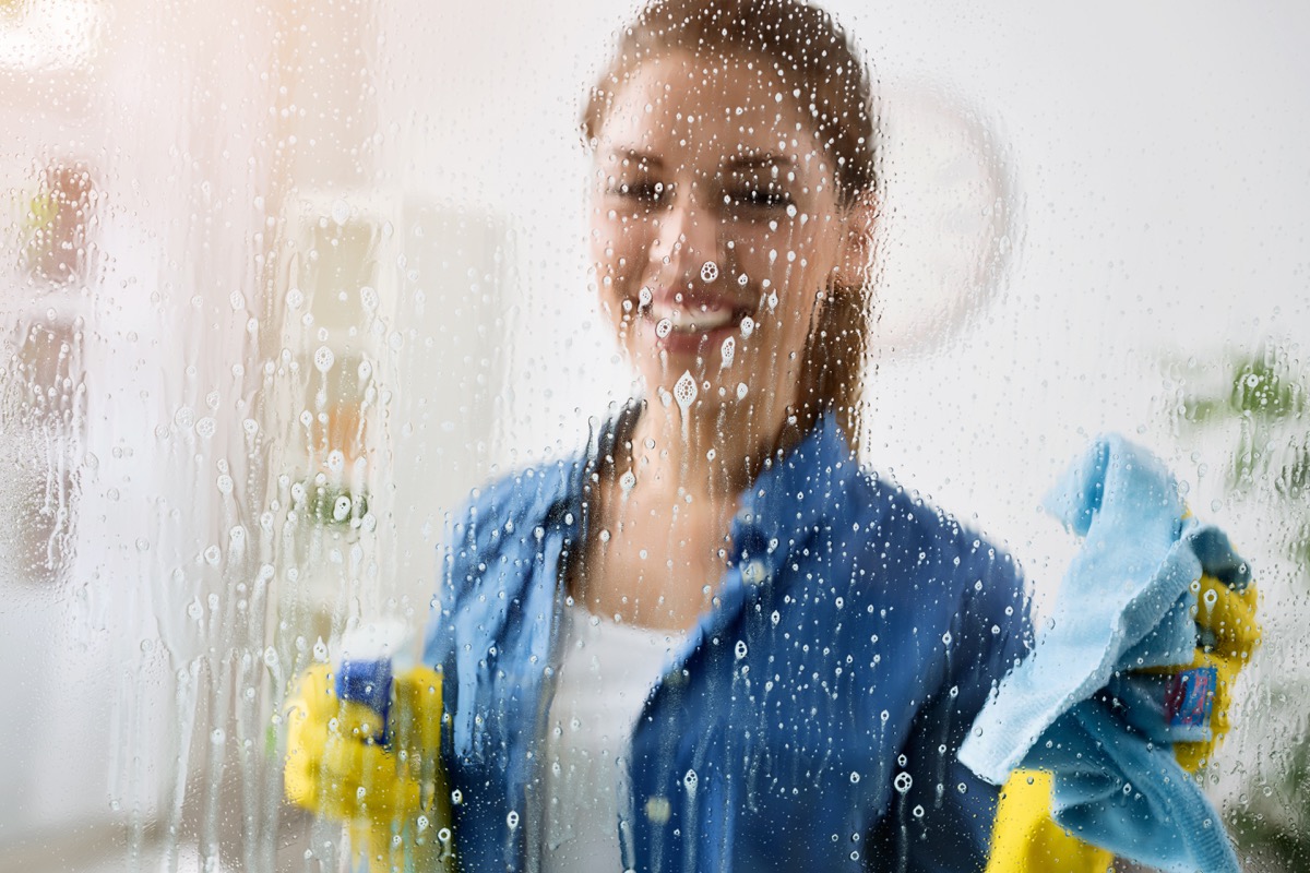 Woman cleaning window with spray