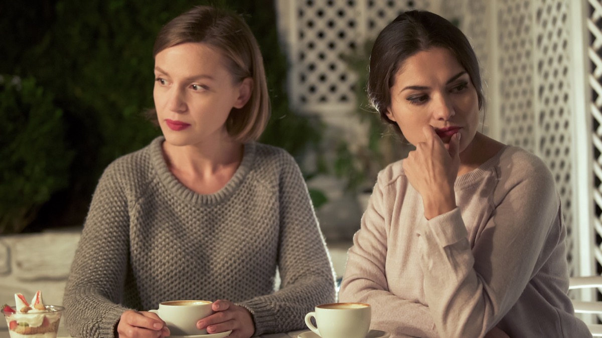 Two upset women have misunderstanding over coffee