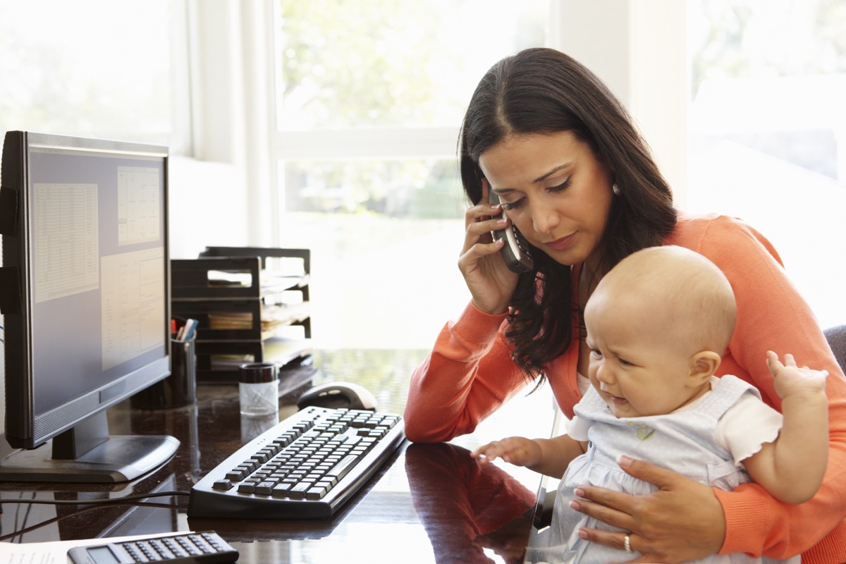Mother working from home taking care of baby