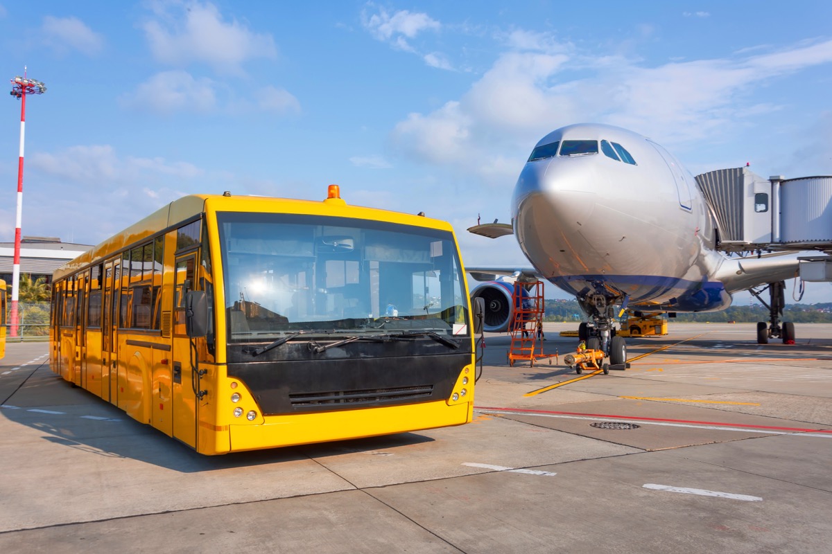 yellow shuttle bus in front of airplane