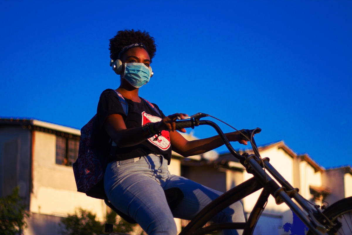 Girl riding bike with a mask on