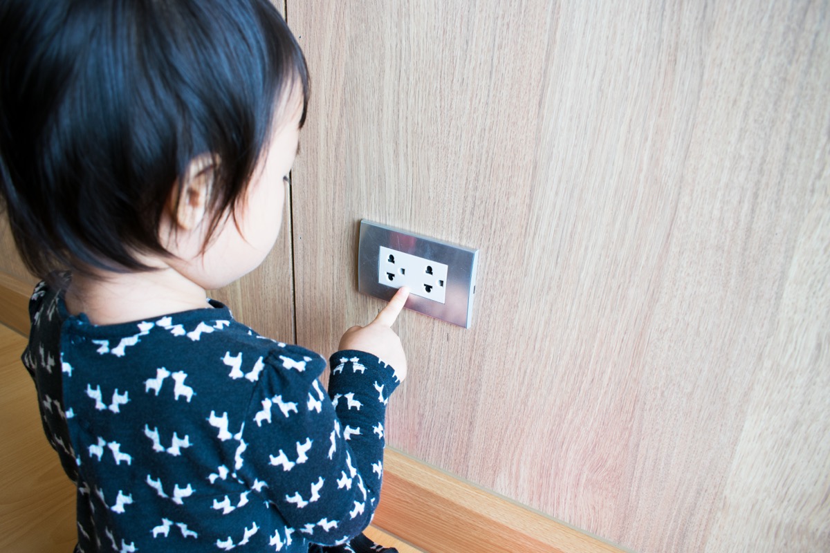 small child tampering with outlet