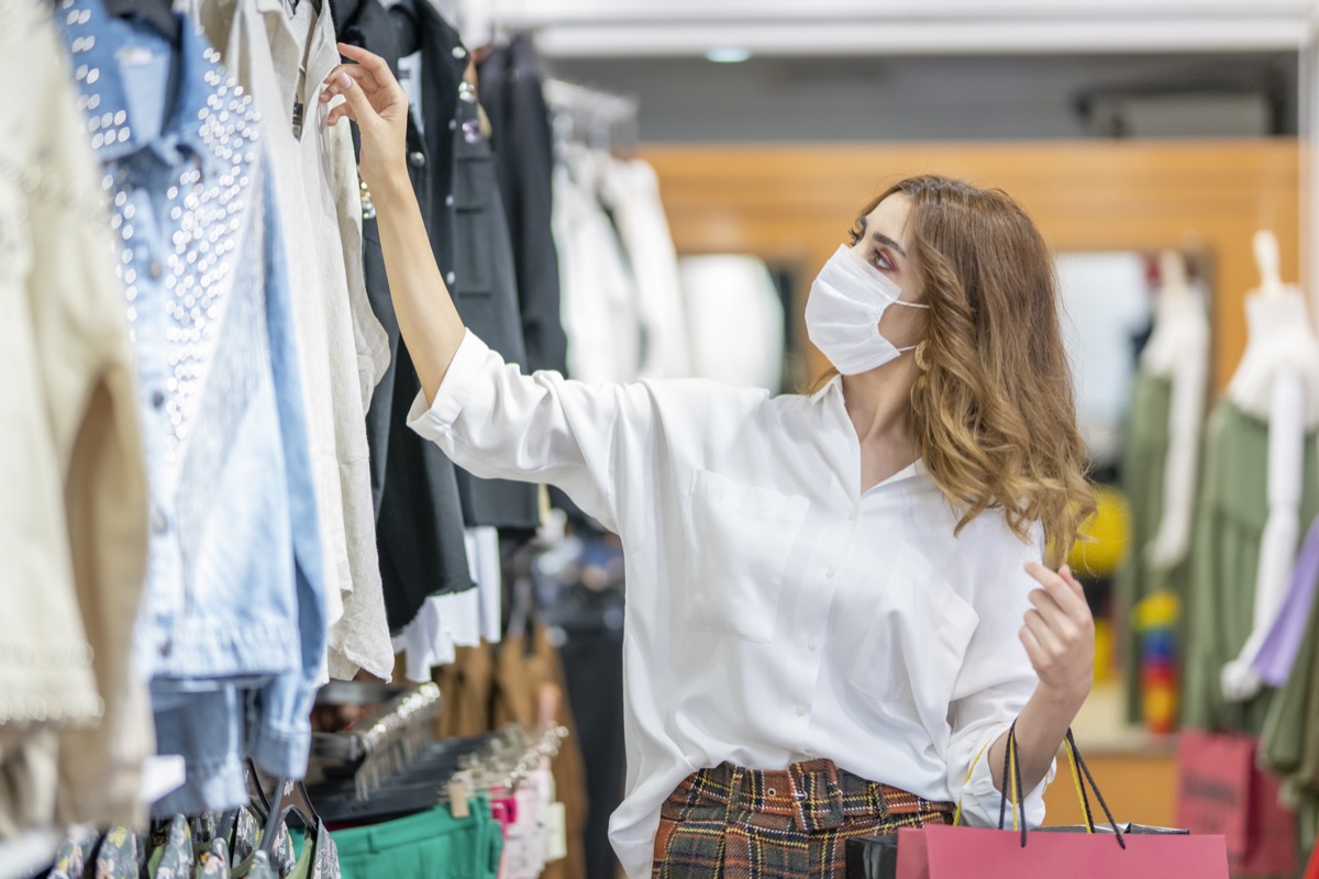 A young woman wears a protective mask while shopping at the Mall.