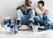 a man and woman paint walls together