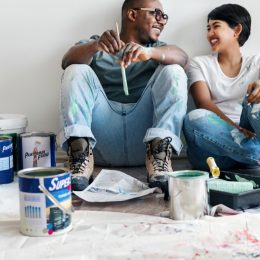 a man and woman paint walls together