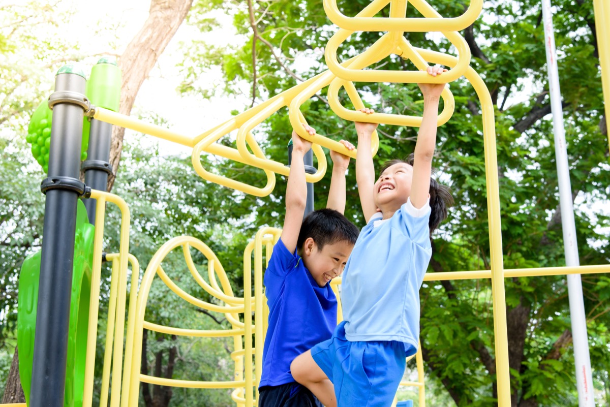 two young boys playing on monkey bars