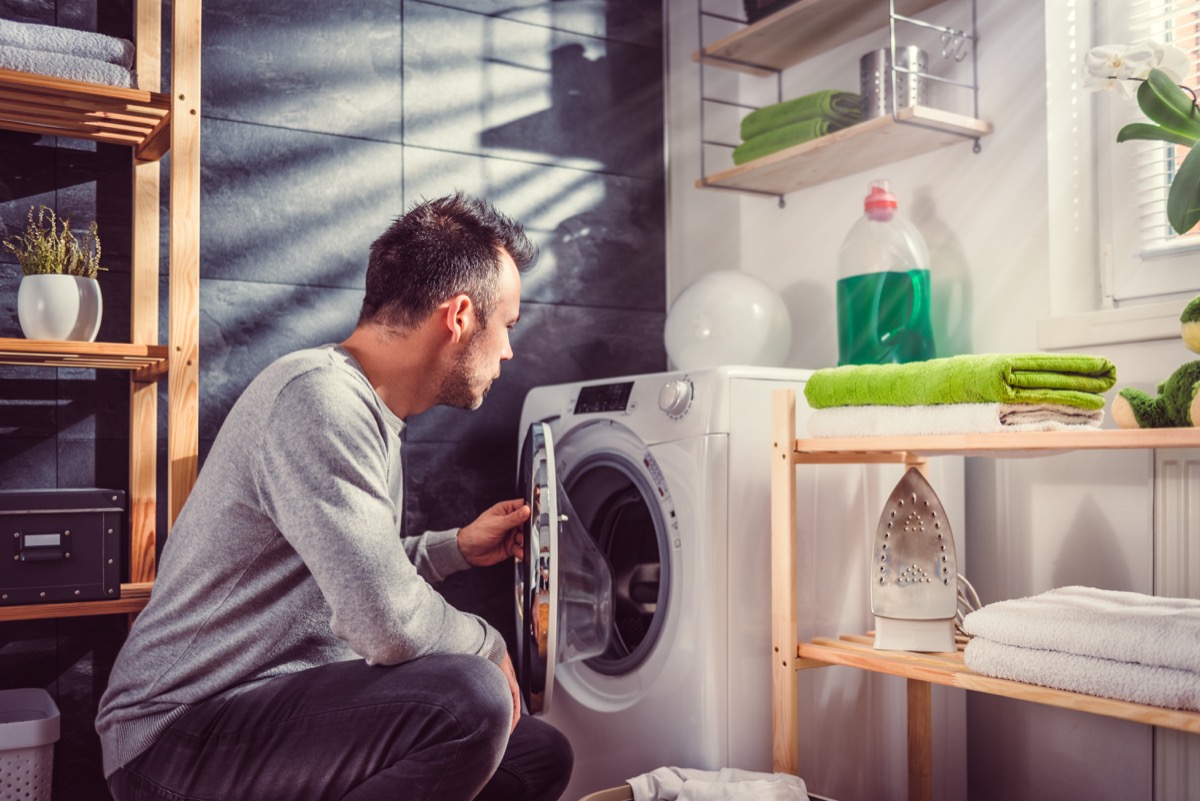 Man cleaning laundry machine