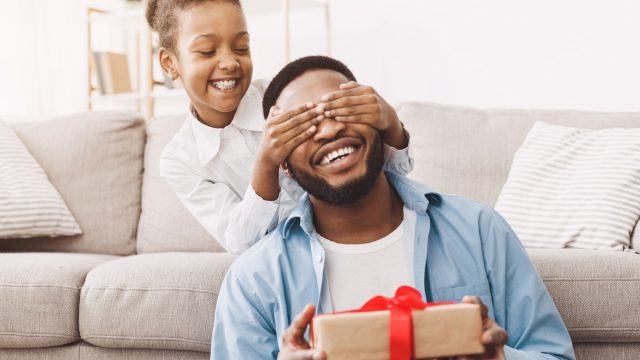 little girl giving dad father's day gift