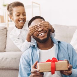 little girl giving dad father's day gift