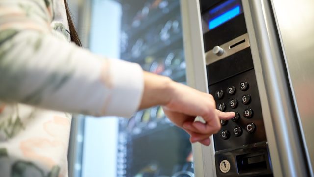Woman touching hotel vending machine