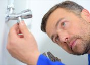 white man inspecting plumbing