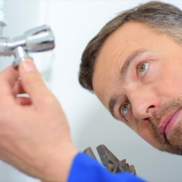 white man inspecting plumbing