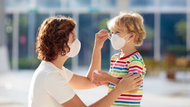 Mother putting a mask on her child