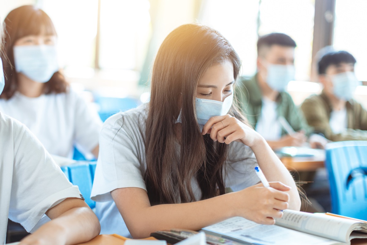 Students wearing protection masks to prevent coronavirus in classroom