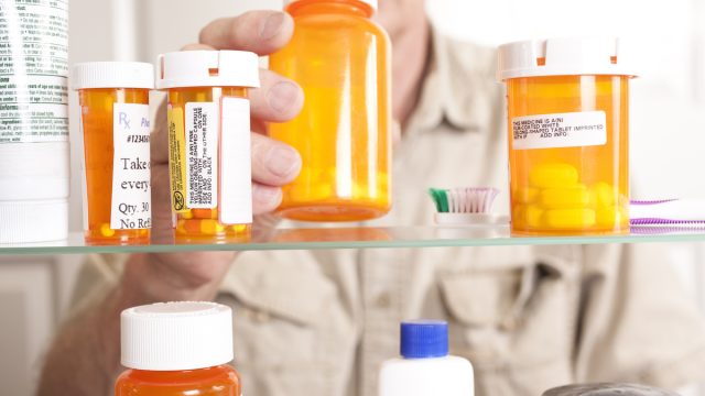 Senior adult man gets prescription medicines out of his medicine cabinet