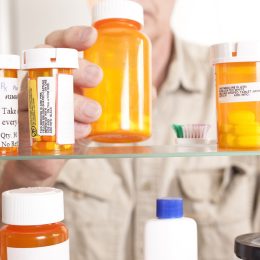 Senior adult man gets prescription medicines out of his medicine cabinet
