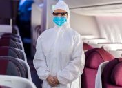 flight attendant wears a hazmat suit in an airplane