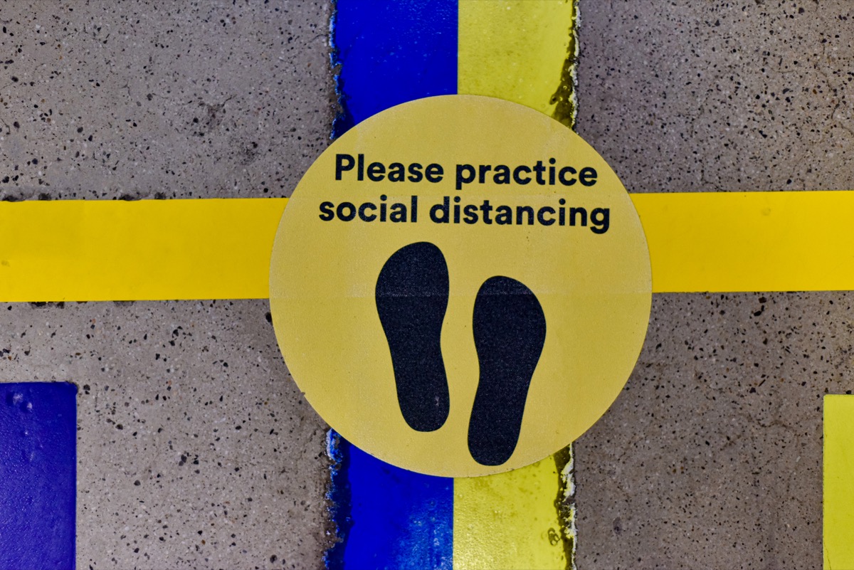 A placeholder label on the ground to reminder shoppers to practice social distancing