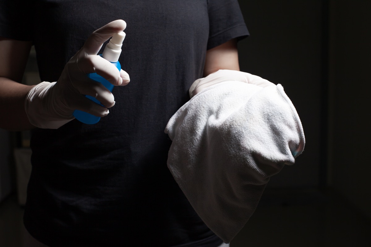 man spraying disinfectant onto white cloth