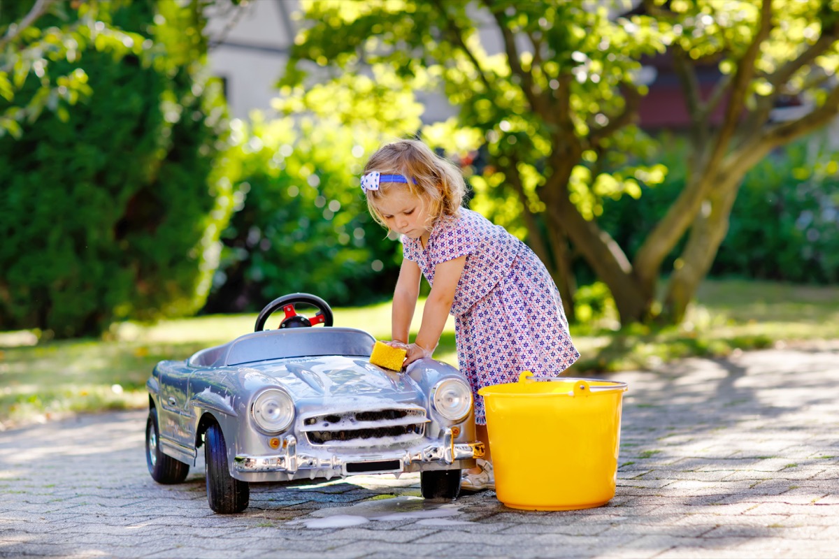 Girl washing play car