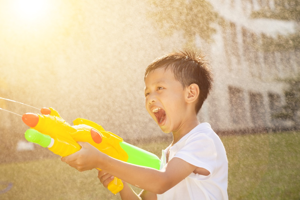 Child spraying water gun