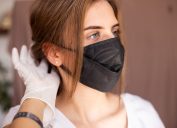 young white woman adjusting face mask ear straps