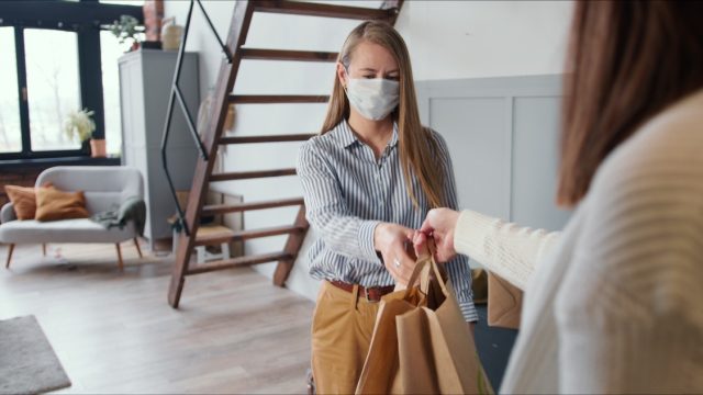 white woman accepting delivery wearing mask
