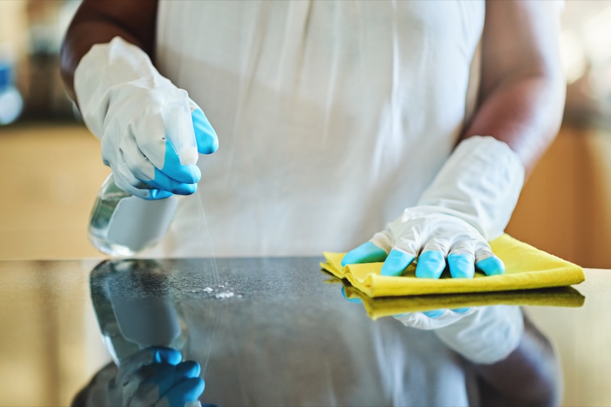 Cropped shot of a woman cleaning a kitchen counter at home