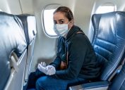 COVID-19 Pandemic border closures. Young woman on the plane returning home city after being stuck in a foreign country as governments have restricted travel to stop the coronavirus spread.