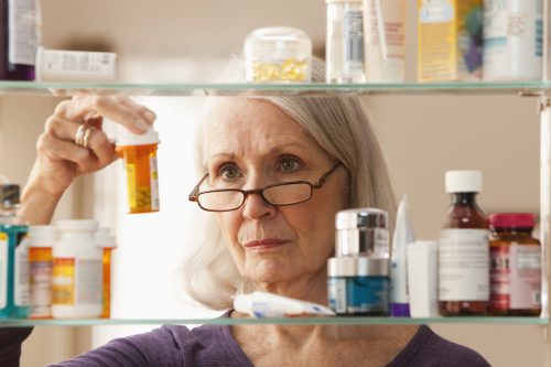 Senior woman looking at prescription bottles