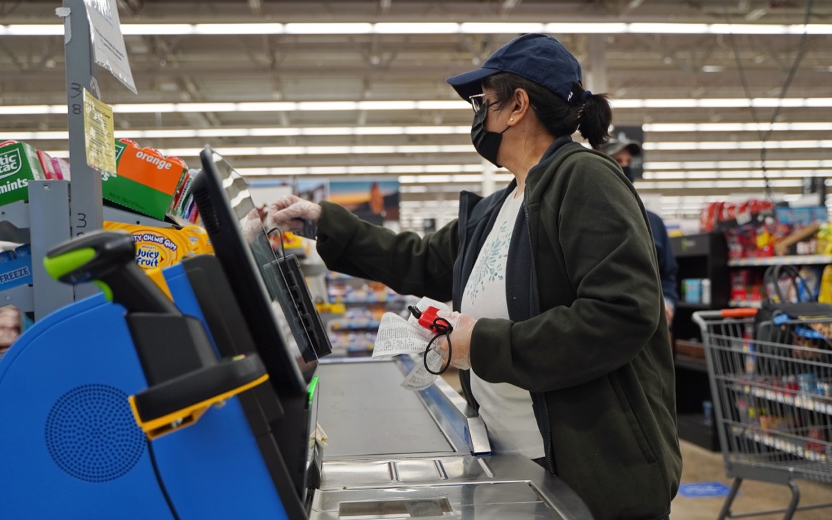woman wearing mask and gloves at walmart checkout
