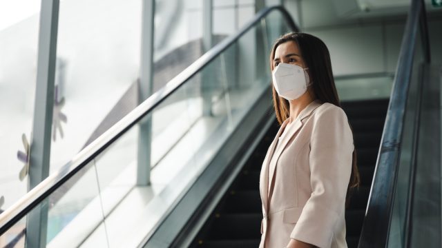woman wearing N95 mask to protect pollution PM2.5 and virus. COVID-19 Coronavirus and Air pollution pm2.5 concept.