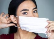 young asian woman putting on face mask