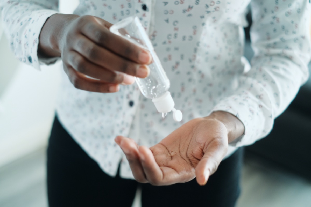 Black woman using hand sanitizer